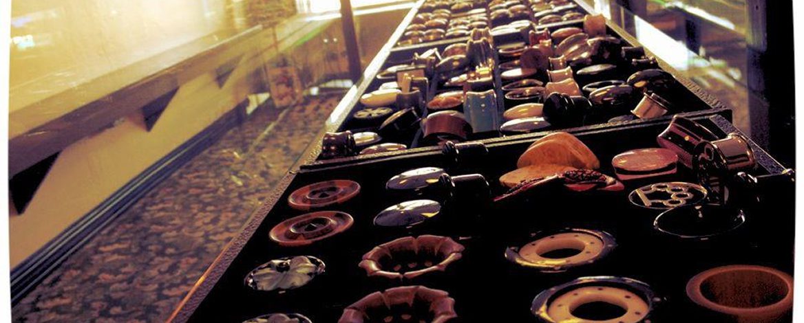 A display case filled with an assortment of vintage radio and television control knobs arranged in rows.
